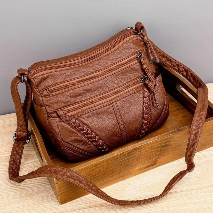 Dames schoudertas met meerdere ritsvakken en vlechtwerk